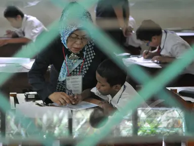 Sejumlah murid SDN 04 Jakarta, mengerjakan soal Ujian Nasional (UN), Senin (18/5/2015). Sebanyak 153.266 peserta didik SD, Madrasah Ibtidaiyah (MI) dan sederajat di Jakarta mengikuti UN yang digelar 18-20 Mei. (Liputan6.com/Herman Zakharia)