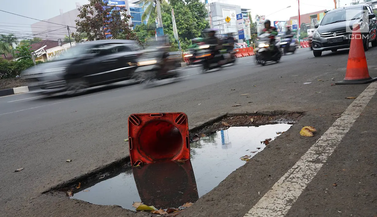 Kendaraan melintas di samping bekas galian proyek yang tidak tuntas pengerjaannya di Jalan Margonda Raya, Depok, Jawa Barat, Kamis (9/5/2019). Kondisi jalan yang diabaikan selama beberapa bulan terakhir tersebut memersempit dan mengganggu aktivitas warga. (Liputan6.com/Immanuel Antonius)