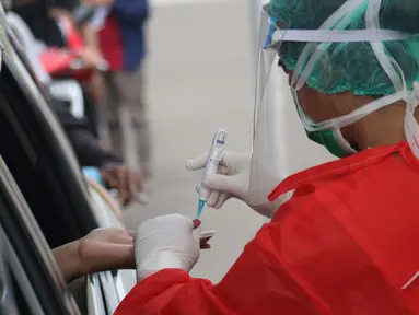 Petugas medis memberi pelayanan tes cepat diagnosa COVID-19 secara drive thru di titik pengecekan Terminal Jatijajar, Depok, Jawa Barat, Kamis (28/5/2020). Tes cepat ini hasilnya akan langsung dikonfirmasi melalui aplikasi dan dilaksanakan hingga Jumat (29/5).  (Liputan6.com/Helmi Fithriansyah)