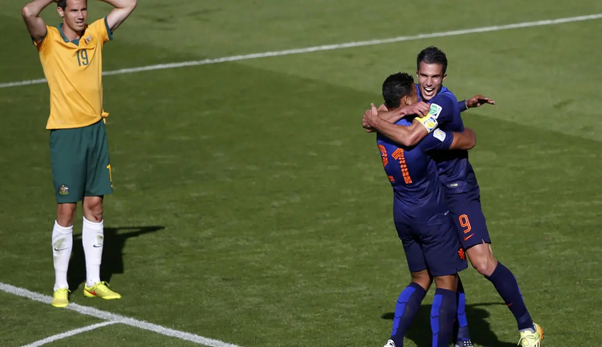 Penyerang Timnas Belanda, Robin van Persie (kanan) memeluk Memphis Depay usai mencetak gol ke gawang Australia dan memastikan satu tempat De Oranje di babak 16 besar, (18/6/2014). (REUTERS/Marko Djurica)