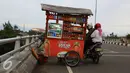 Pedagang minuman menjajakan dagangan menggunakan gerobak di atas jalan layang Pasar Rebo, Jakarta, Sabtu (14/1). Padahal aktivitas tersebut berbahaya bagi keselamatan mereka serta pengendara lain. (Liputan6.com/Immanuel Antonius)