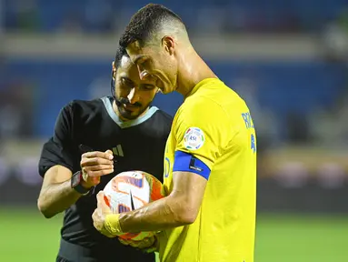 Penyerang Al Nassr, Cristiano Ronaldo meminta tanda tangan wasit setelah mencetak tiga gol ke gawang Al Fateh usai pertandingan Liga Pro Saudi di Stadion Pangeran Abdullah Bin Jalawi di al-Hasa, Jumat, 26 Agustus 2023. (AFP/Ali Al-Haji)
