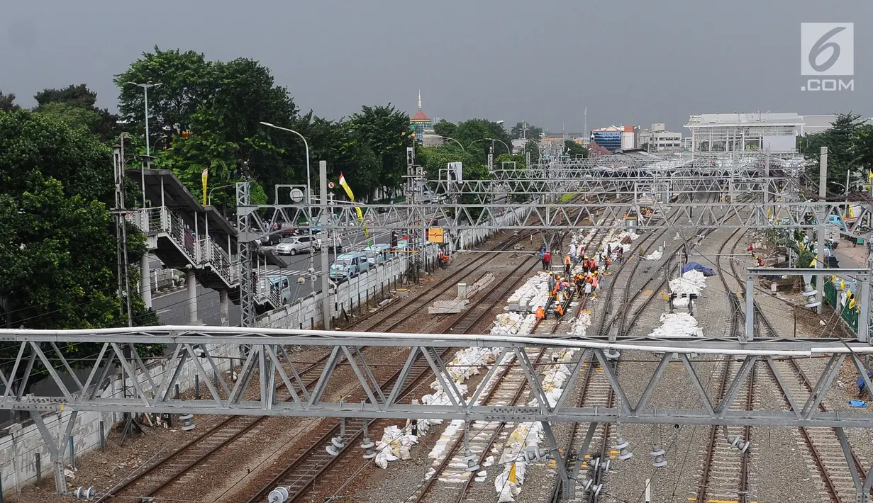 Aktivitas pekerja di jalur dwiganda atau double-double track (DDT) kawasan Cipinang, Jakarta, Jumat (12/4). DDT Jatinegara-Cakung memiliki panjang 9,5 kilometer dari panjang lintas DDT Manggarai-Cikarang yakni 35 Km. (Liputan6.com/Herman Zakharia)