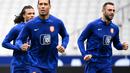 Bek Belanda Nathan Ake (kiri) dan bek Belanda Virgil Van Dijk (tengah) melakukan pemanasan dalam sesi latihan di Stade de France di Saint-Denis, utara Paris pada 23 Maret 2023. (AFP/Franck Fife)