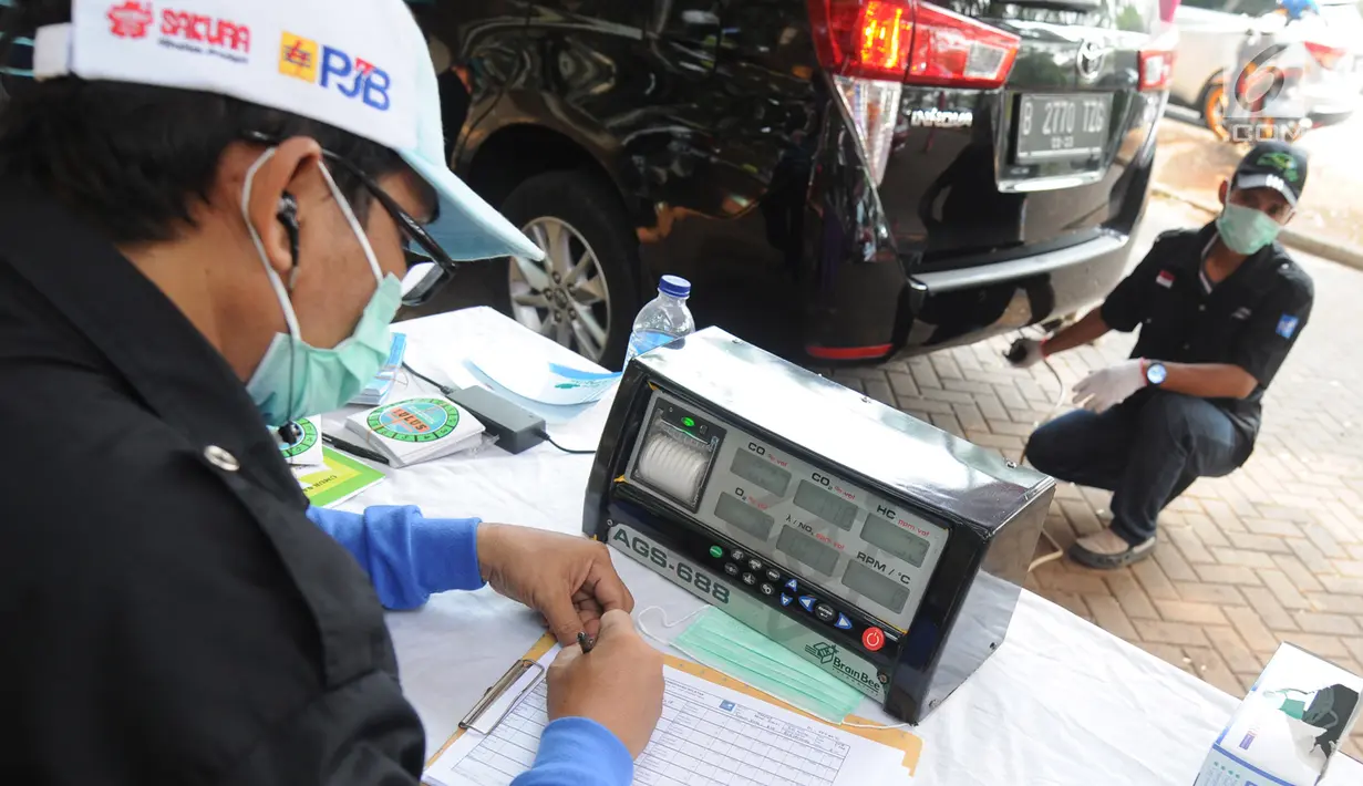 Petugas mengukur kadar emisi kendaraan saat dilakukan uji emisi di Taman Kota 1 BSD, Tangerang Selatan, Rabu (3/10). Dinas Lingkungan Hidup (DLH) Kota Tangerang Selatan menggelar uji emisi guna menekan angka polusi kendaraan. (Merdeka.com/Arie Basuki)