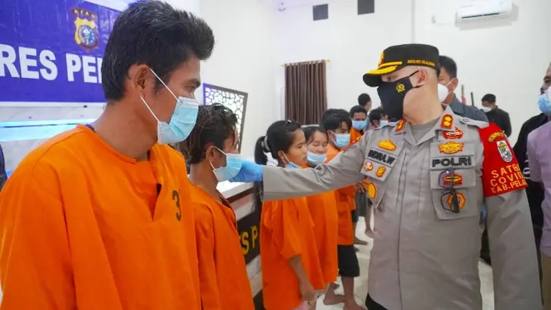 Kepala Polres Pelalawan AKBP Indra Wijatmiko berbincang dengan seorang tersangka penganiayaan sadis yang menuduh korbannya sebagai dukun santet.