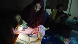 Warga membaca Alquran saat melakukan iktikaf di sebuah masjid di Bandung (6/6). Mereka melakukan iktikaf di masjid dengan mendirikan tenda. (AFP/Timur Matahari)