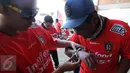 Salah satu suporter membantu memasangkan gelang tiket masuk Stadion I Wayan Dipta, Gianyar, Bali, Minggu (30/8/2015). Jelang pembukaan turnamen Piala Presiden 2015, ribuan suporter menyerbu stadion Dipta, Gianyar, Bali. (Liputan6.com/Helmi Fithriansyah) 