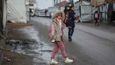 Seorang gadis kecil berjalan menuju sekolah di Deir al-Balah, di Jalur Gaza tengah, pada 10 Desember 2025. Secara bertahap, anak-anak di Gaza mulai kembali ke sekolah. (BASHAR TALEB/AFP)