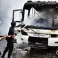 Petugas Pemadam Kebakaran berusaha memadamkan api yang membakar Bus Biang Lala di Jalan MH. Thamrin, Jakarta, Jumat (10/12). (Antara)