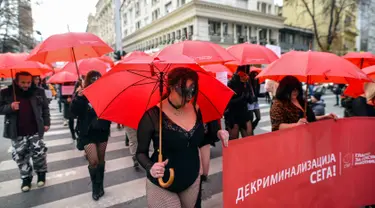 Sejumlah pekerja seks membawa payung merah saat menggelar unjuk rasa di Skopje, Makedonia, Senin (17/12). Mereka menyerukan dihentikannya kekerasan terhadap pekerja seks dan penerapan hukuman bagi pelakunya. (Robert ATANASOVSKI/AFP)