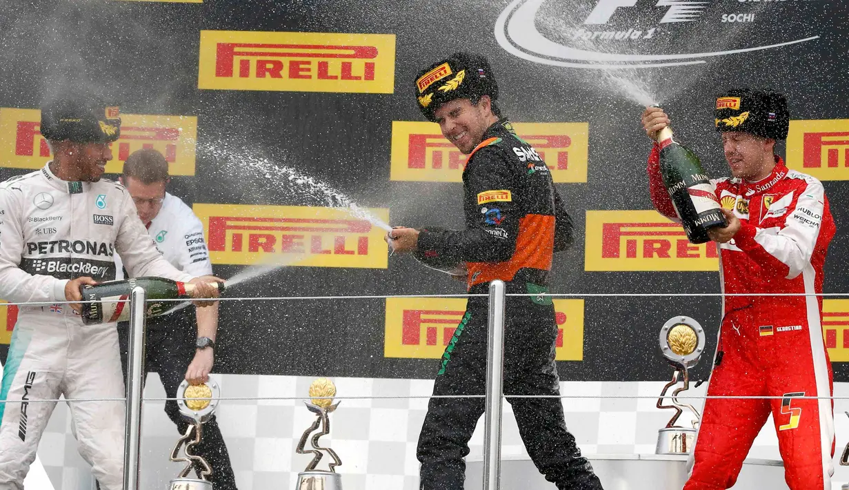 Pebalap F1 tim Mercedes Lewis Hamilton, pembalap tim Force India Sergio Perez dan pembalap F1 tim Ferrari, Sebastian Vettel menyemprotkan sampanye saat merayakan kemenangan usai ajang balap GP F1 Rusia di Sochi, Minggu (11/10/2015).(REUTERS/Grigory Dukor)