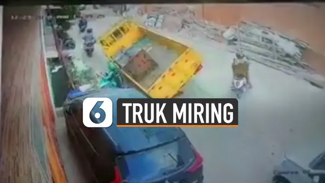 Terekam kamera CCTV sebuah truk miring saat lewati jalanan berlubang.