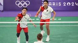 Pemain ganda putra Indonesia, Muhammad Rian Ardianto (kiri) mengembalikan bola serve saat menghadapi wakil Prancis, Lucas Corvee/Ronan Labar pada laga Grup C Olimpiade Paris 2024 di Porte De La Chapelle Arena, Paris, Senin (29/7/2024). Fajar Alfian/Muhammad Rian Ardianto menang dua gim langsung 21-13, 21-10. (Dok. NOC Indonesia/Naif Muhammad Al'as)