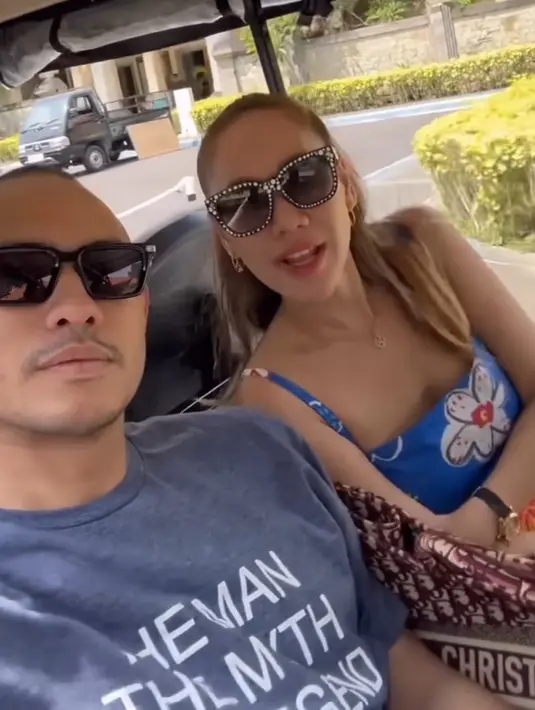 Sampai di Bali, BCL mengenakan atasan crop biru motif bunga dengan aksesori kacamata hitam beraksen beads. Dipadukan bawahan waena orange. [@tikoaryawardhana]