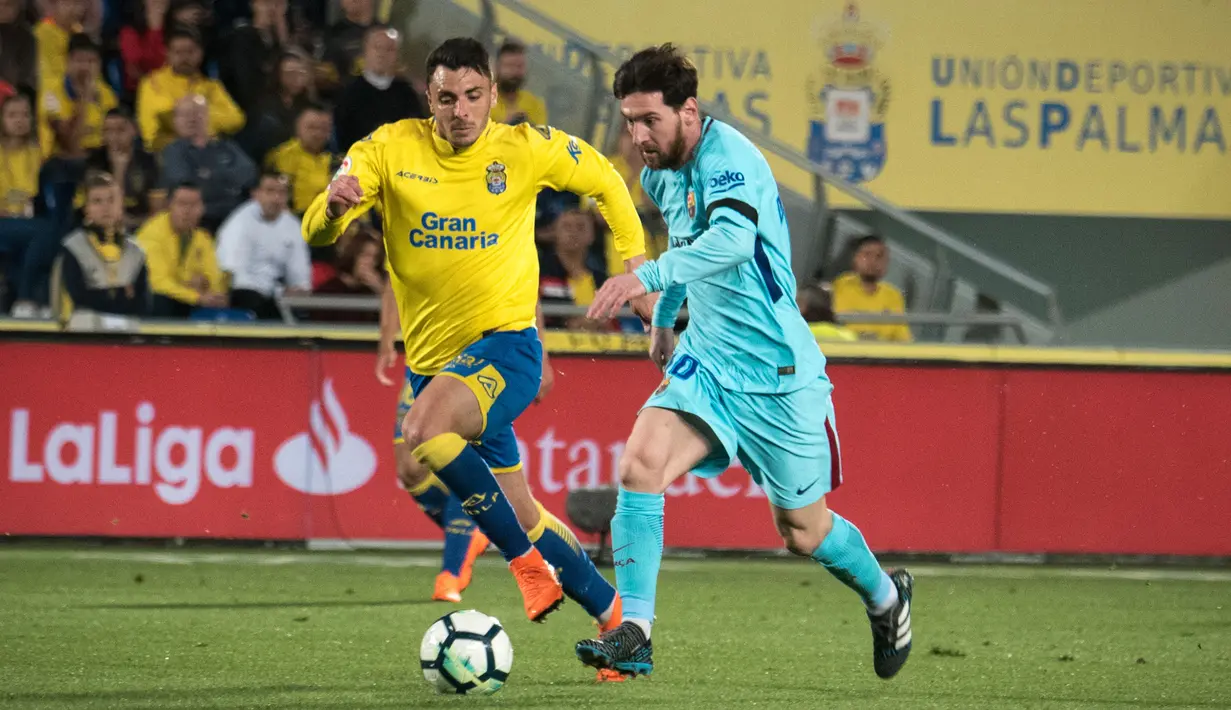 Gelandang Barcelona, Lionel Messi, menggiring bola melewati bek Las Palmas, Ximo Navarro, pada laga La Liga Spanyol di Stadion Gran Canaria, Las Palmas, Kamis (1/3/2018). Kedua klub bermain imbang 1-1. (AFP/Desiree Martin)