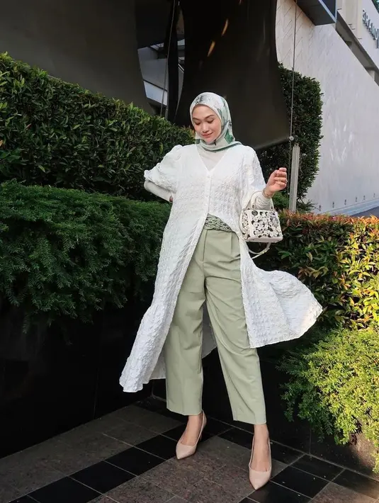Padukan cardigan putih dengan celana kulot warna sage. Agar lebih hidup, kamu bisa kenakan hijab bermotif warna senada. (Instagram/indahnadapuspita).