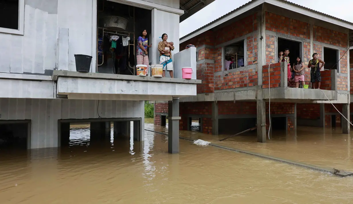 Banjir juga menyebabkan ratusan bahkan ribuan warga harus mengungsi dari rumah mereka. Tampak dalam foto, warga memandang dari rumah mereka yang terendam banjir tinggi di Hat Yai, Provinsi Songkhla, Thailand selatan, pada Rabu 26 November 2025. (Sarot Meksophawannakul/THAI NEWS PIX/AFP)