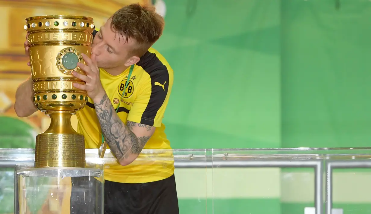 Gelandang Dortmund, Marco Reus, mencium Piala DFB Pokal usai mengalahkan Frankfurt pada laga final di Stadion Olympic, Berlin, Sabtu (27/5/2017). Dortmund menang 2-1 atas Frankfurt. (EPA/Clemens Bilan)