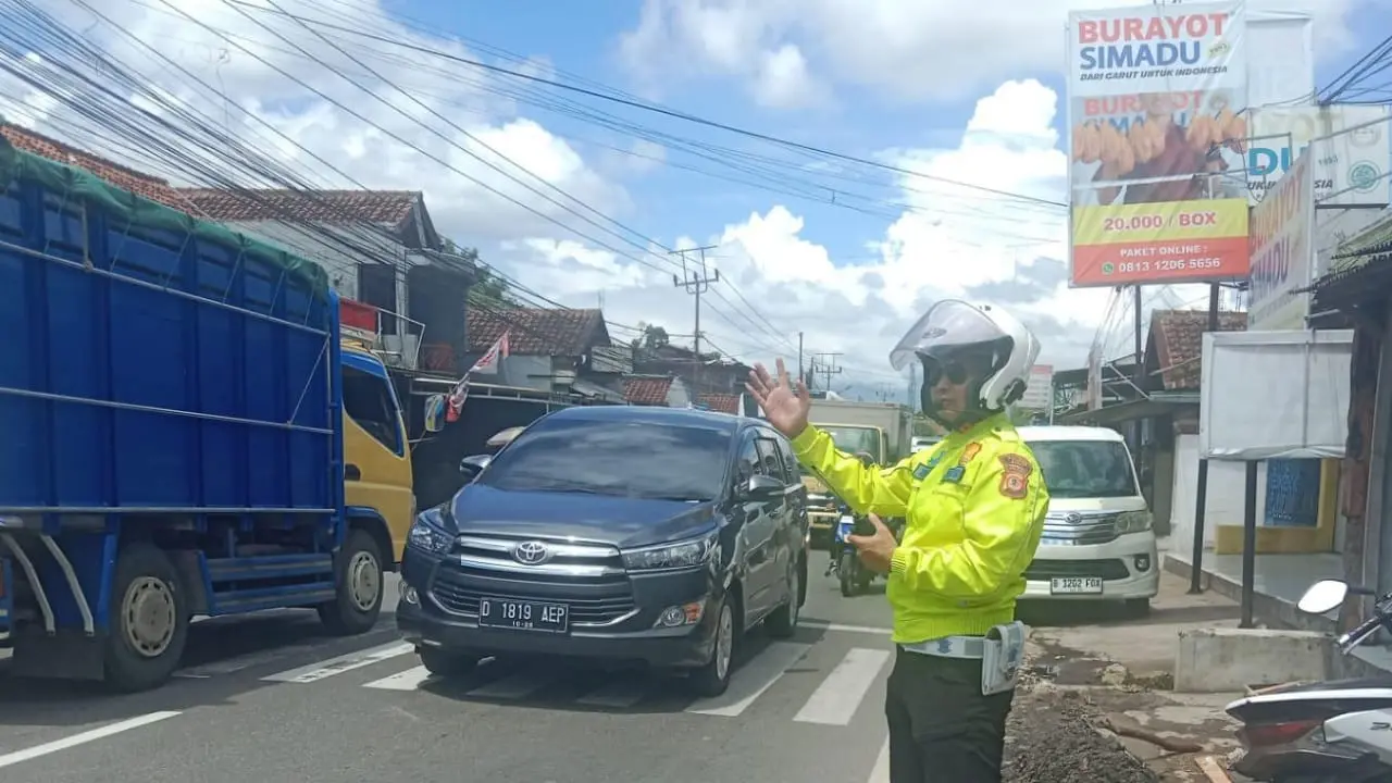 Seorang petugas tengah melakukan rekayasa one way di jalur pemudik via Garut, Jawa Barat pada puncak arus balik lebaran Idul Fitri 1446H/2025. (Liputan6.com/Jayadi Supriadin)