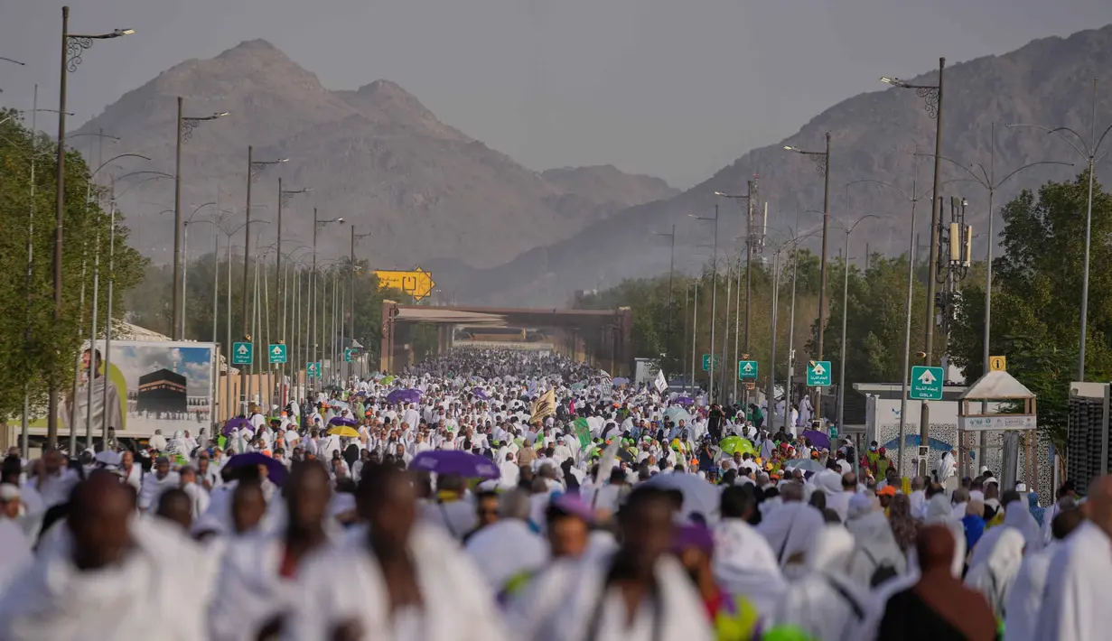 Umat Muslim berjalan menuju bukit berbatu yang dikenal sebagai Jabal Rahmah atau Gunung Rahmat, di Dataran Arafah, selama ibadah haji tahunan di dekat kota suci Mekah, Arab Saudi, Selasa 26 Mei 2026. (AP Photo/Altaf Qadri)