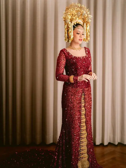 Hanggini tampil menawan dengan kebaya maroon dihiasi payetan yang tampak begitu indah. Lengkap dengan aksesori kalung dan gelangnya. Hanggini pun tampil dengan gaya rambut sanggul dihiasi suntiang dan ronce melati khas pengantin Sumatera. [Foto: IG/@venemapictures]