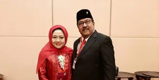 Dampingi suami bertugas, Dewi tampil anggun kenakan kebaya kutubaru merah sederhana yang dipadukan dengan angkin dan hijab warna senada. [@dewiranokarno].