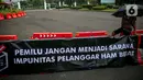 Poster bertuliskan "Pemilu Jangan Menjadi Sarana Impunitas pelanggaran HAM Berat" saat anggota Jaringan Solidaritas Korban untuk Keadilan (JSKK) melakukan Aksi Kamisan ke-795 di seberang Istana Merdeka, Jakarta, Kamis (16/11/2023). (Liputan6.com/Faizal Fanani)