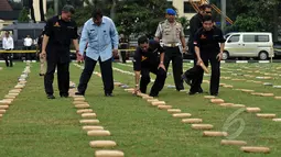 Kabareskrim Mabes Polri, Komjen Pol Budi Waseso (tengah) meletakan barang bukti ganja saat rilis pengungkapan di Lapangan Bhayangkara, Jakarta, Senin (11/5/2015). 2,1 ton ganja kering asal Aceh diamankan Ditnarkoba Mabes Polri. (Liputan6.com/JohanTallo)