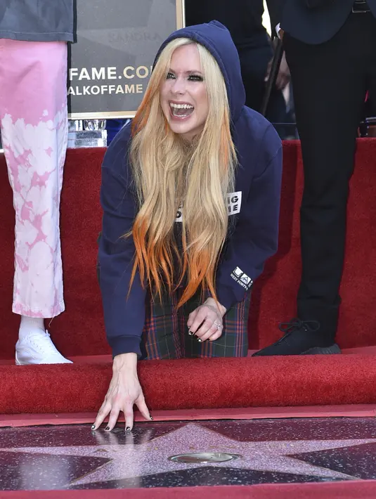 Penyanyi Avril Lavigne berpose di atas bintang barunya di Hollywood Walk of Fame setelah upacara  penghargaan untuknya, di Los Angeles, Rabu (31/8/2022). Penerimaan bintang Hollywood Walk of Fame sekaligus menjadi perayaan 20 tahun album perdana Lavigne yang bertajuk Let Go.  (Photo by Richard Shotwell/Invision/AP)