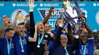Kapten Leicester City, Wes Morgan, dan pelatih Claudio Ranieri mengangkat trofi juara Liga Inggris seusai mengalahkan Everton 3-1 di Stadio King Power, Leicester, Sabtu (7/5/2016). (AFP/Adrian Dennis)