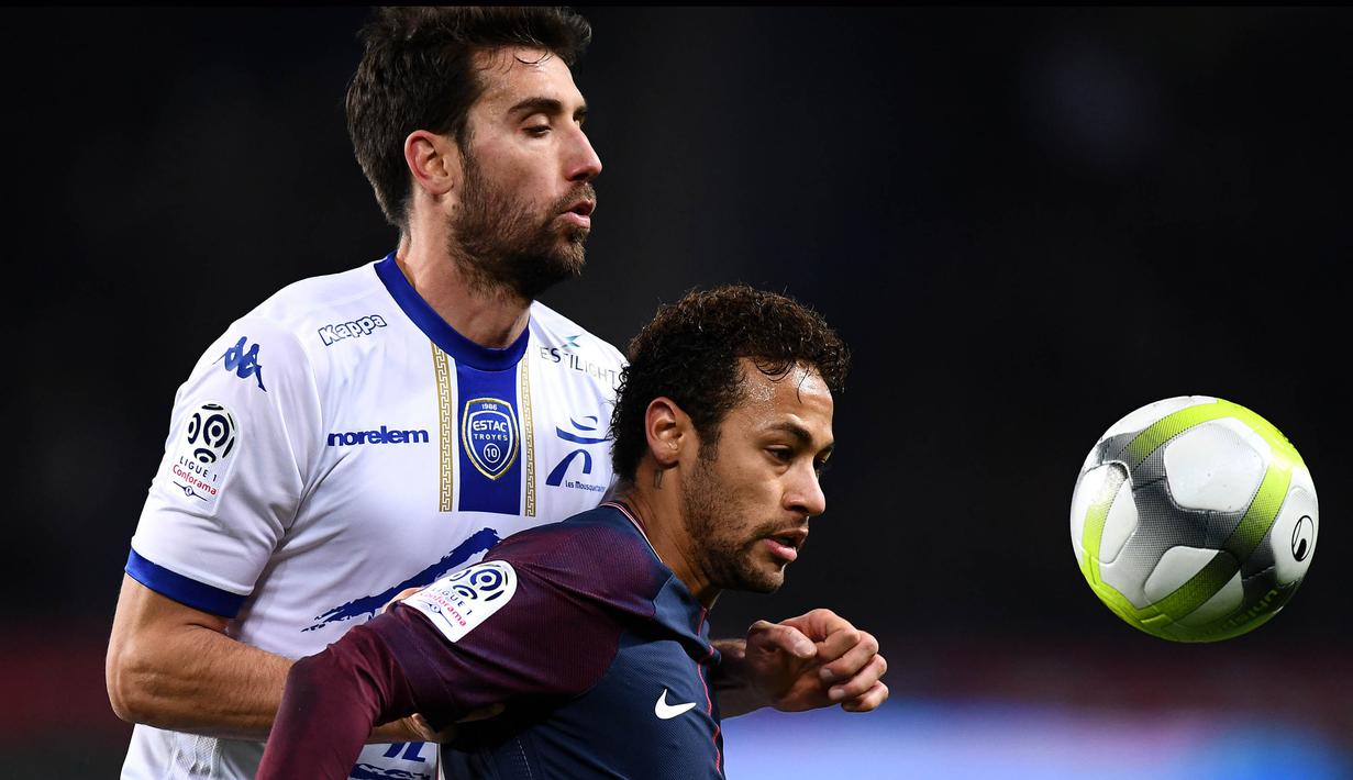 Striker PSG, Neymar, berusaha melewati penjagaan bek Troyes, Mathieu Deplagne, pada laga Ligue 1 Prancis di Stadion Parc des Princes, Paris, Rabu (29/11/2017). PSG menang 2-0 atas Troyes. (AFP/Franck Fife)