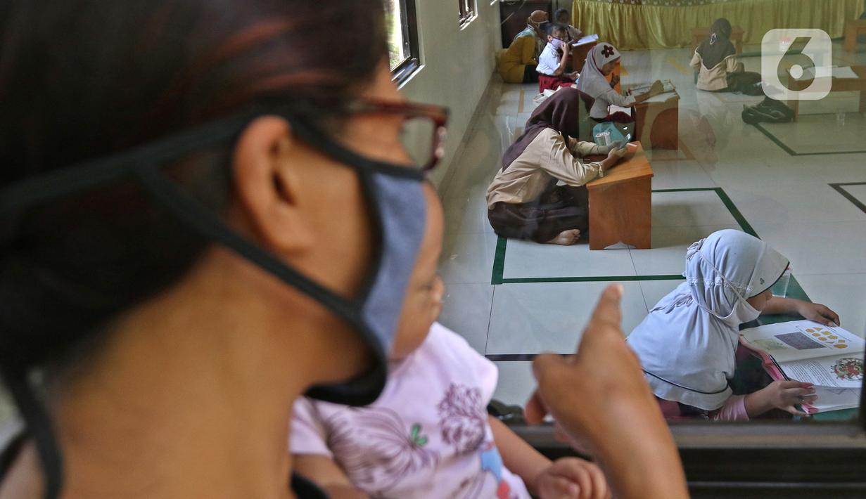 Sejumlah siswa belajar di Aula Kelurahan Jatirahayu, Bekasi, Jawa Barat, Rabu (29/7/2020). Pemerintah Kota Bekasi melalui Kelurahan Jatirahayu menyediakan fasilitas wifi gratis bagi siswa yang terkendala kuota internet dalam kegiatan belajar secara daring. (Liputan6.com/Herman Zakharia)