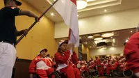 Atlet angkat berat Indonesia, Ni Nengah Widiasih mencium bendera Merah Putih dalam acara pelepasan kontingen Indonesia ke ASEAN Para Games (APG) 2017 di Hotel Lorin Solo, Selasa (12/9/2017). (Bola.com/Ronald Seger)