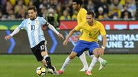 Penyerang Argentina, Lionel Messi (kiri) berusaha mengiring bola dari kawalan gelandang Brasil, Renato Augusto pada laga persahabatan di MCG di Melbourne (9/6). Argentina menang atas Brasil dengan skor 1-0. (AFP Photo/Mal Fairclough)