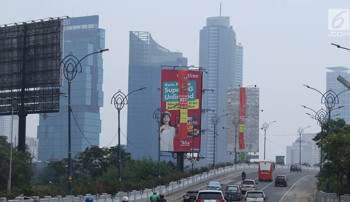 Sejumlah kendaraan melintas di sisi papan reklame di sekitar Jalan HR Rasuna Said, Jakarta, Sabtu (20/12). Pemerintah Provinsi DKI Jakarta akan menurunkan sebanyak 60 papan reklame yang dianggap melakukan pelanggaran. (Liputan6.com/Helmi Fithriansyah)