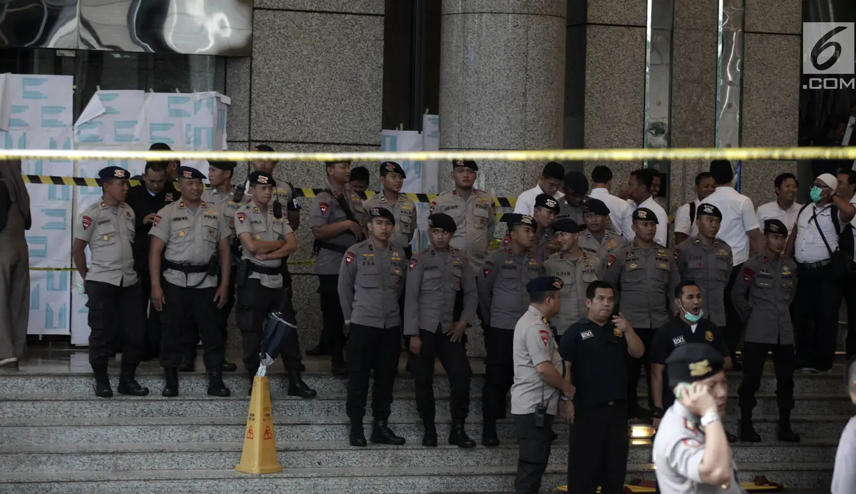 Petugas kepolisian memasang garis polisi di sekitar lokasi Gedung BEI, Jakarta, Senin (15/1). Demi keamanan dan keselamatan, pihak keamanan menutup area sekitar lokasi gedung BEI yang ambruk. (Liputan6.com/Arya Manggala)