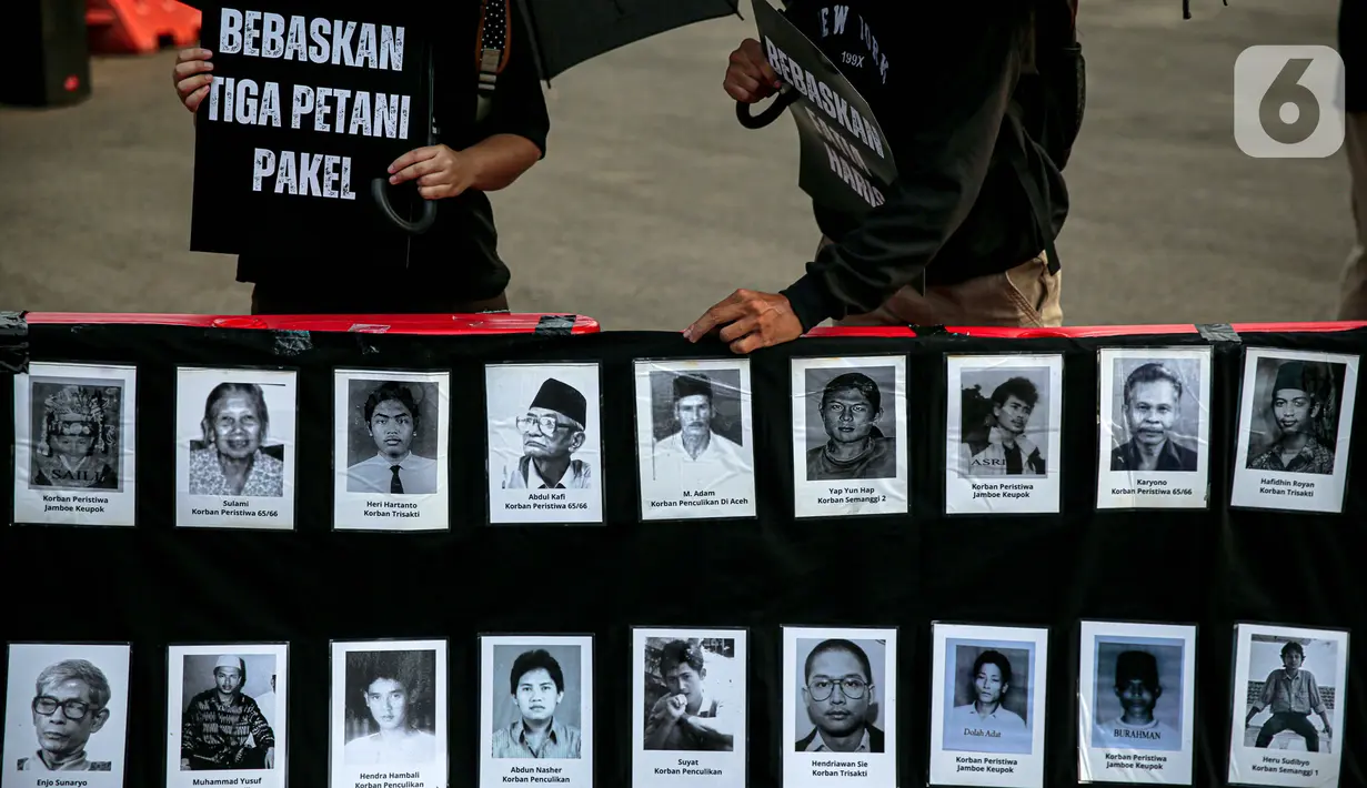 Anggota Jaringan Solidaritas Korban untuk Keadilan (JSKK) membawa foto para korban pelanggaran HAM saat melakukan Aksi Kamisan ke-795 di seberang Istana Merdeka, Jakarta, Kamis (16/11/2023). (Liputan6.com/Faizal Fanani)