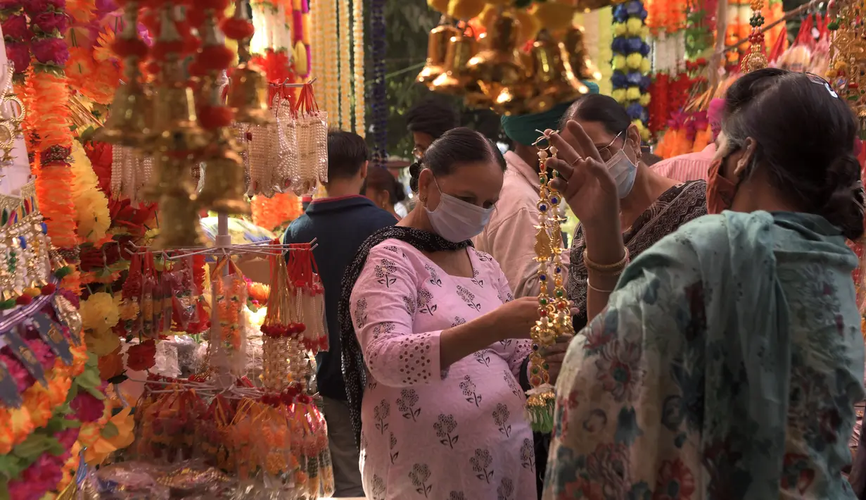 Orang-orang membeli barang-barang dekorasi menjelang festival Diwali di sebuah pasar di Amritsar, India pada 10 November 2020. Tahun ini festival lampu Diwali jatuh pada 14 November mendatang. (Photo by NARINDER NANU / AFP)