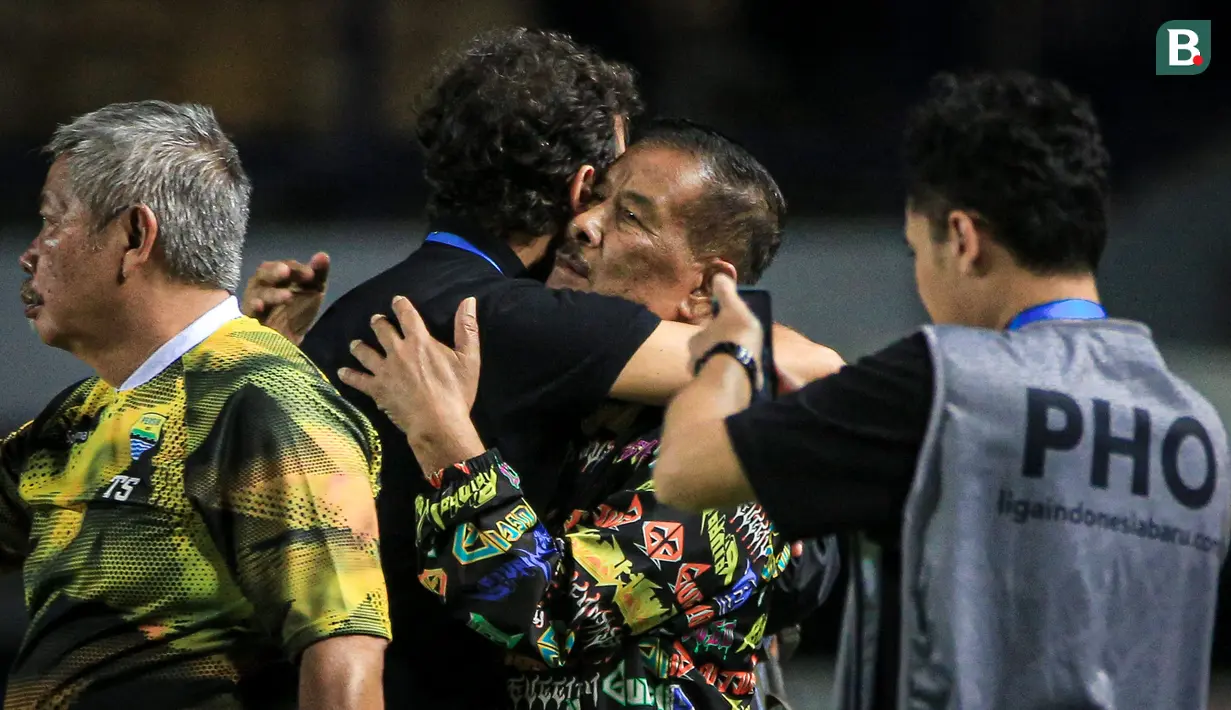 Pelatih kepala Persib Bandung, Luis Milla (tengah kiri) memeluk Komisaris PT Persib Bandung Bermartabat (PBB), Umuh Muchtar setelah laga pekan ketiga BRI Liga 1 2023/2024 antara Persib Bandung melawan Dewa United di Stadion GBLA, Bandung, Jumat (14/07/2023). (Bola.com/Bagaskara Lazuardi)