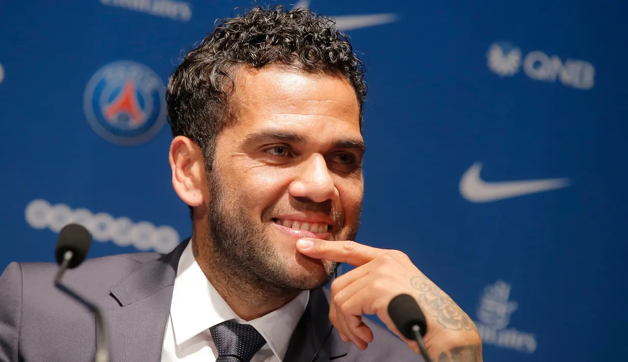 Senyum Dani Alves saat konferensi pers kepindahannya ke PSG di stadion Parc des Princes di Paris, Prancis, (12/7). Alves akan mengenakan seragam nomor punggug 32, sama seperti yang dipakainya di Juventus. (AP Photo/Michel Euler)