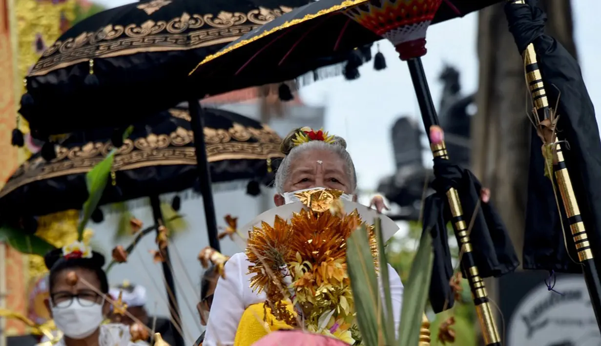 Anggota keluarga kerajaan berparade sebelum upacara ngaben untuk mendiang Raja Ida Cokorda Pemecutan XI atau Anak Agung Ngurah Manik Parasara di Denpasar, Bali, 21 Januari 2022. Anak Agung Ngurah Manik Parasara meninggal pada Desember lalu di usia 76 tahun. (SONY TUMBELAKA/AFP)
