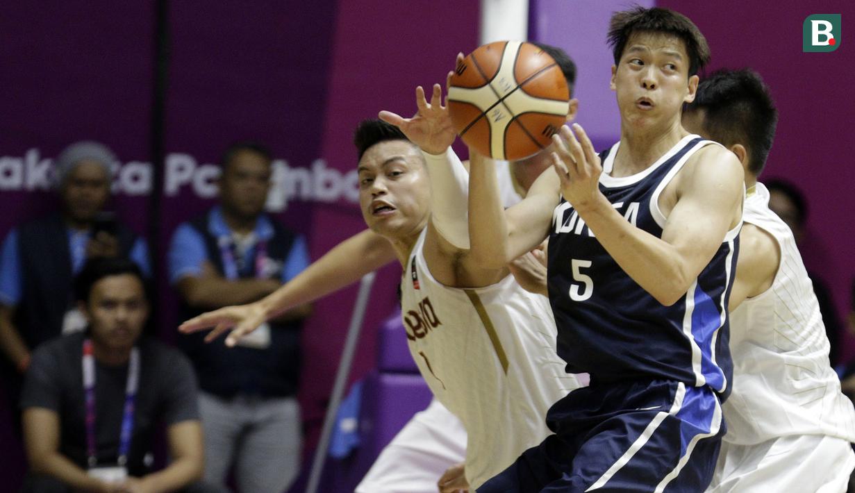 Pebasket Indonesia, Andakara Prastawa Dhyaksa, berusaha merebut bola dari pebasket Korea Selatan, Sunhyung Kim, pada laga Asian Games 2018 di Hall Basket GBK, Selasa (14/8/2018). Indonesia takluk 65-104 dari Korsel. (Bola.com/Peksi Cahyo)