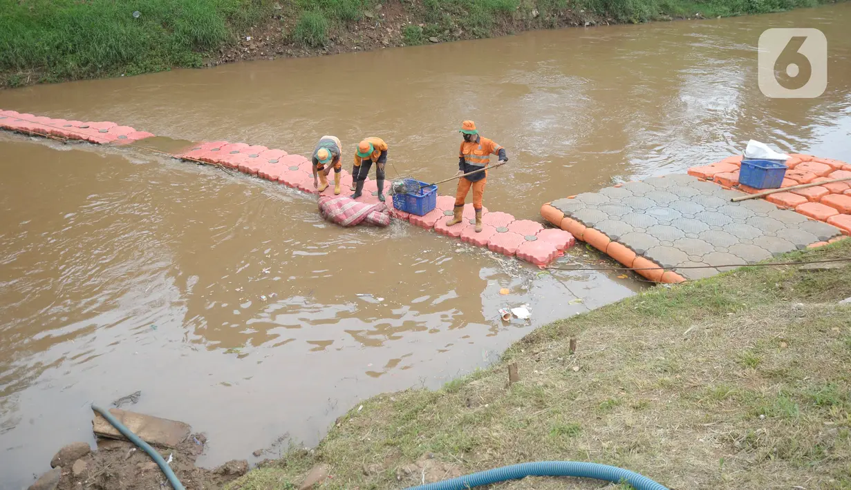 Pekerja Dinas Kebersihan mengangkat sampah kasur di Kali Pesanggrahan, Jakarta Selatan, Rabu (4/11/2020). Sampah-sampah yang terbawa arus air terjaring di penyaringan sampah yang dipasang untuk mengantisipasi penyumbatan pada musim penghujan bisa terjadi banjir. (merdeka.com/Dwi Narwoko)