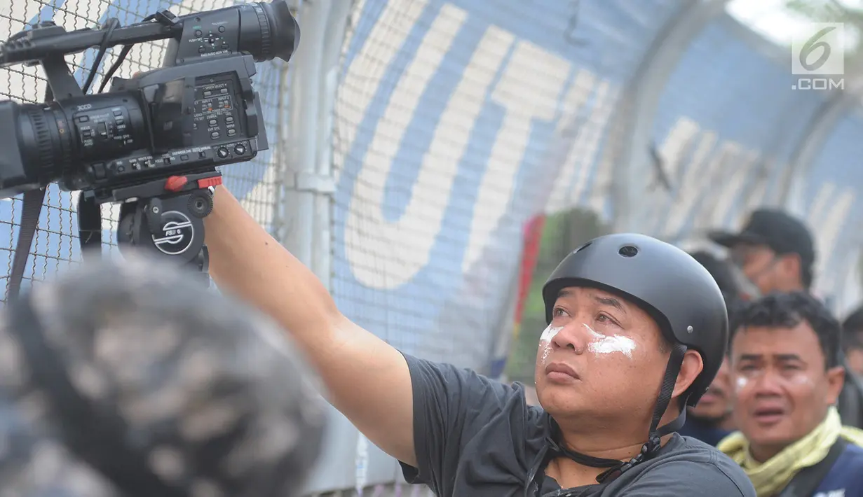 Jurnalis mengoleskan pasta gigi ke wajahnya saat demontrasi yang memanas di depan gedung DPR, Senayan, Jakarta, Selasa (24/9/2019). Polisi menembakkan gas air mata dan meriam air untuk membubarkan massa aksi yang menolak RKUHP dan RUU kontroversial lain. (merdeka.com/Arie Basuki)