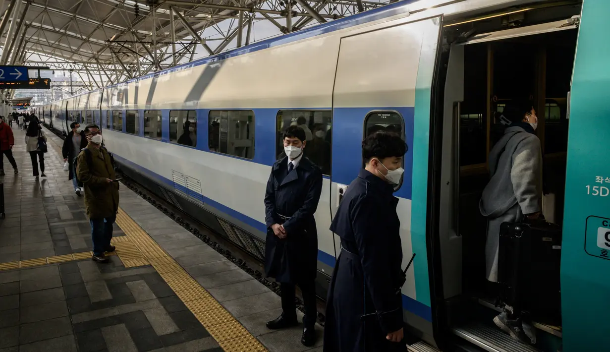 Penumpang menaiki kereta menjelang liburan Tahun Baru Imlek di stasiun kereta api Seoul, Korea Selatan, Rabu (10/2/2021). Sebelumnya pada Minggu, 31 Januari 2021, otoritas memperpanjang dua pekan kewajiban jaga jarak untuk jaga-jaga menyusul libur tahun baru China atau imlek. (Ed JONES/AFP)