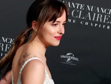 Aktris Dakota Johnson berpose saat menghadiri penayangan perdana film terbarunya, Fifty Shades Freed di Salle Pleyel di Paris, Prancis (6/2). Aktris 28 tahun ini tampil cantik dan seksi dengan gaun putih yang dikenakannnya. (AP Photo/Francois Mori)