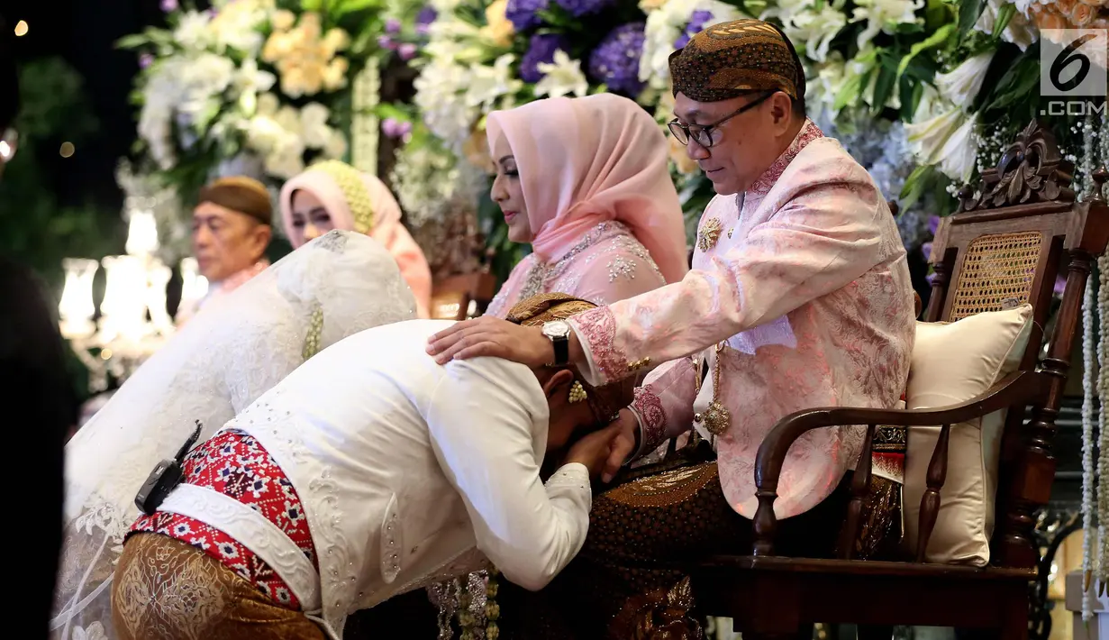 Putra Ketua MPR, Ray Zulham Farras Nugraha mencium tangan ayahnya, Zulkifli Hasan saat acara pernikahan di Jakarta, Minggu (24/9). Acara pernikahan tersebut di hadiri beberapa Tokoh dan Pejabat Publik. (Liputan6.com/Johan Tallo)