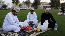 Warga Oman berkumpul untuk berbuka puasa di pantai di Muscat selama bulan suci Ramadhan pada 12 April 2022. Umat islam di seluruh dunia saat ini tengah melaksanakan bulan Ramadhan dan berpuasa selama satu bulan. (MOHAMMED MAHJOUB / AFP)