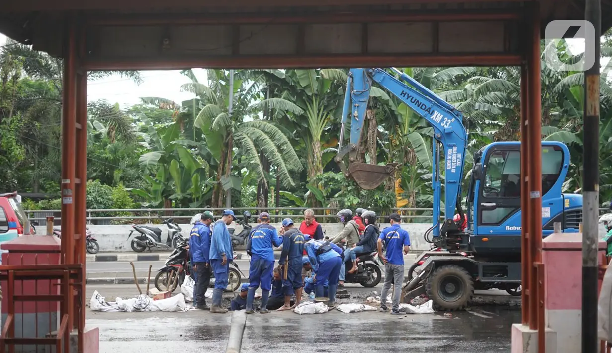 Petugas Sudin SDA Jakarta Timur dibantu alat berat membersihkan saluran gorong-gorong yang tertutup lumpur dan sampah di kawasan Pasar Rebo, Kamis (19/3/2020). Pembersihan untuk memperlancar sistem drainase yang tersumbat dan kerap menimbulkan genangan air. (Liputan6.com/Immanuel Antonius)